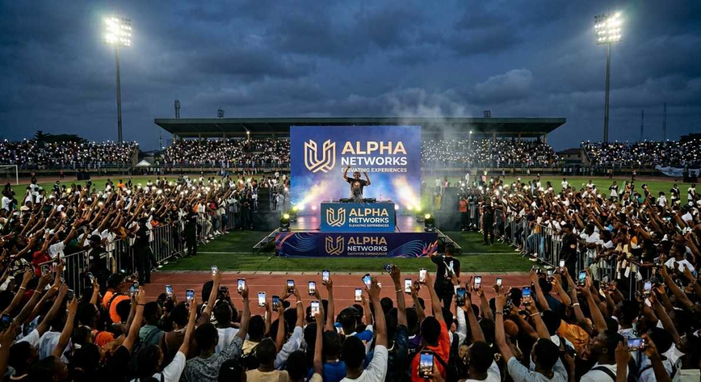 HiSL matchday halftime brand activation, DJ on stage, packed university stadium, students recording, founding partner backdrop West Africa